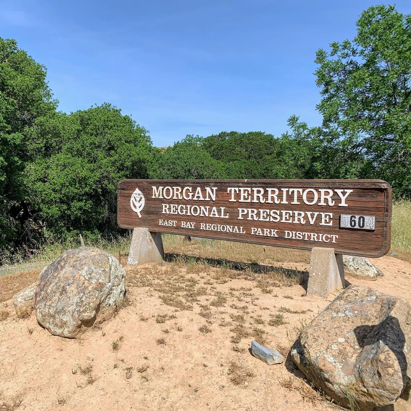The wooden sign of Morgan Territory Regional Preserve between big boulders.